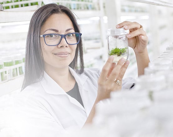 Woman in a lab holding a jar containing a specimen