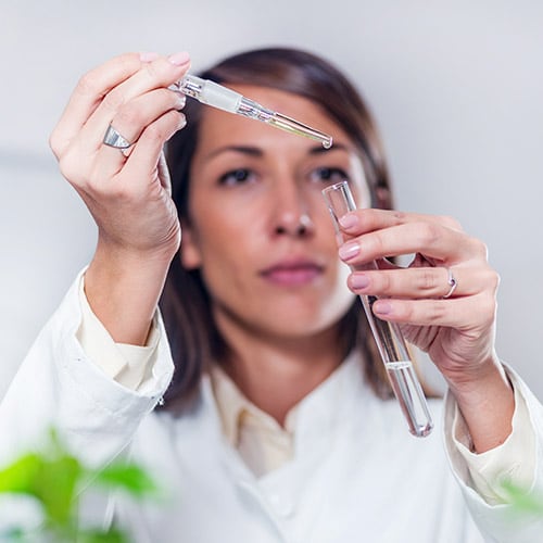 Woman in a lab coat holding a test tube