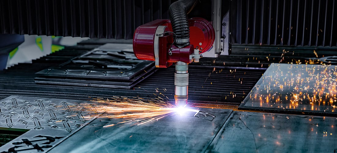 Machine laser cutting a pattern on steel in Costa Rica manufacturing plant